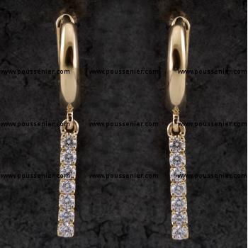 creole earrings with hinge system with a U-shaped profile under which a bar with castle-set brilliant cut diamonds