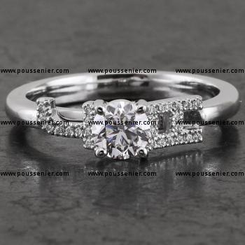 handmade solitaire ring with a with a central brilliant cut diamond flanked by the letters J & A pavé set with smaller brilliant cut diamonds 
